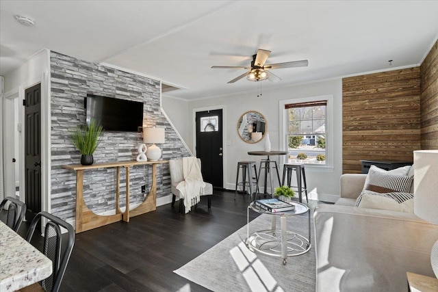 living room featuring ceiling fan, dark wood-style floors, baseboards, and ornamental molding