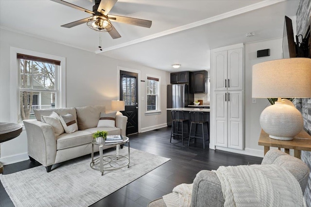 living area featuring ceiling fan, crown molding, baseboards, and dark wood-style flooring