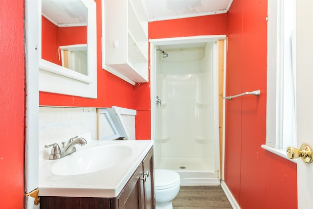 full bath with a shower stall, toilet, vanity, and wood finished floors