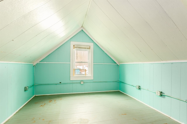 additional living space with hardwood / wood-style floors and lofted ceiling