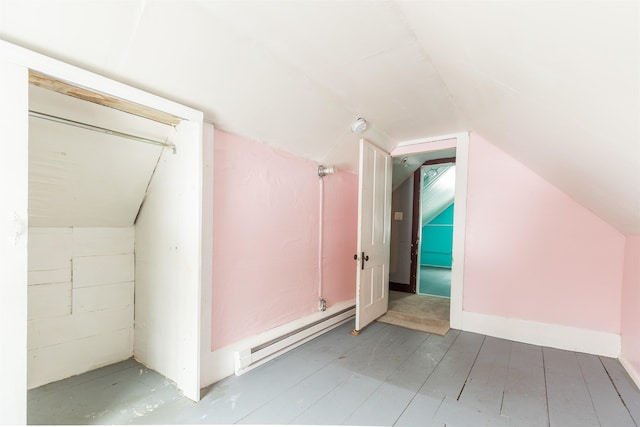 additional living space with a baseboard heating unit and lofted ceiling