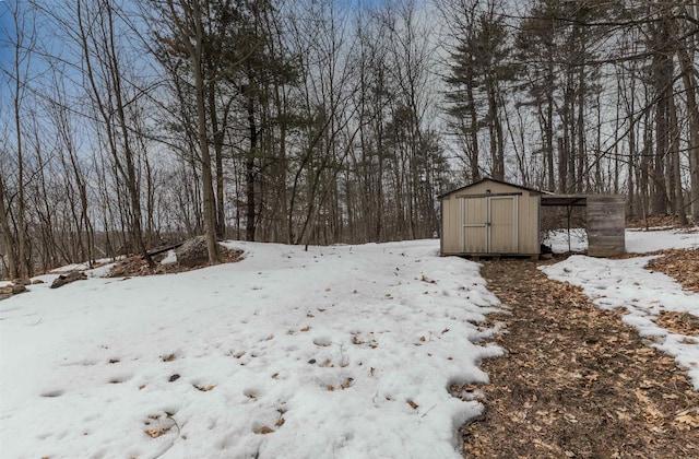 yard layered in snow with an outbuilding and a storage unit