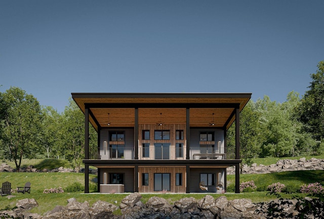 rear view of house featuring a yard and a balcony