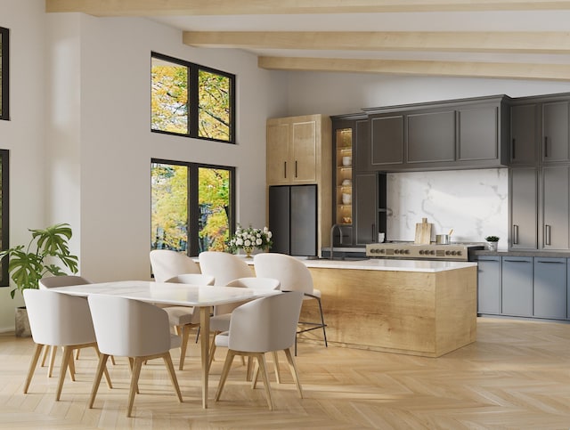 kitchen featuring tasteful backsplash, beamed ceiling, light countertops, high vaulted ceiling, and a sink