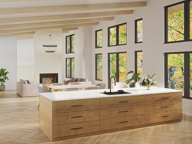 kitchen with brown cabinets, a warm lit fireplace, modern cabinets, and a sink