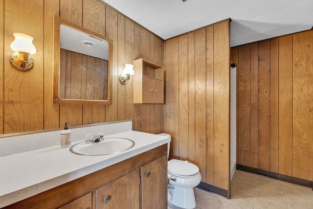 bathroom with vanity, tile patterned floors, wooden walls, and toilet