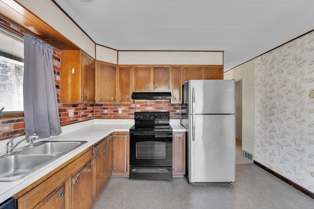 kitchen with ventilation hood, black range with electric stovetop, brown cabinets, freestanding refrigerator, and a sink