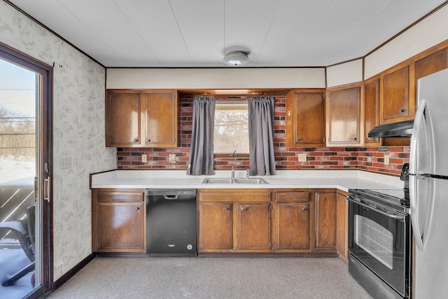 kitchen featuring under cabinet range hood, wallpapered walls, black appliances, and light countertops