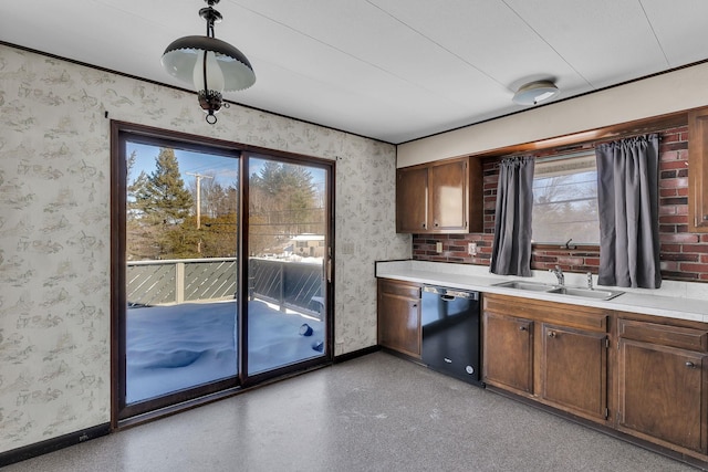 kitchen with a sink, black dishwasher, light countertops, and wallpapered walls