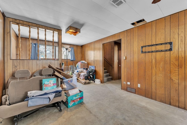 rec room with visible vents, concrete flooring, and wooden walls