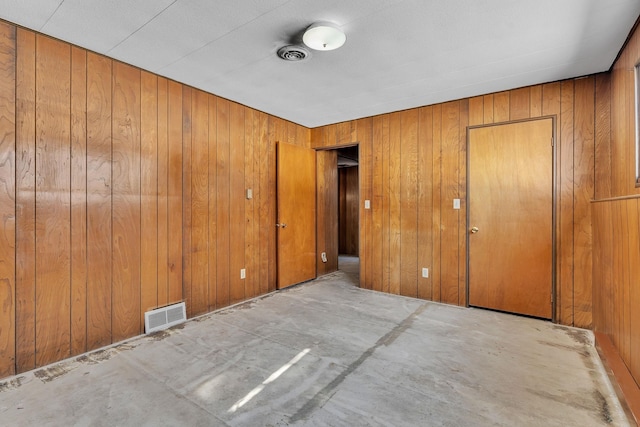 unfurnished bedroom featuring visible vents and wooden walls