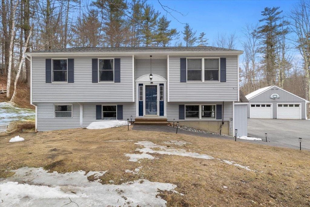 bi-level home featuring an outbuilding and a detached garage