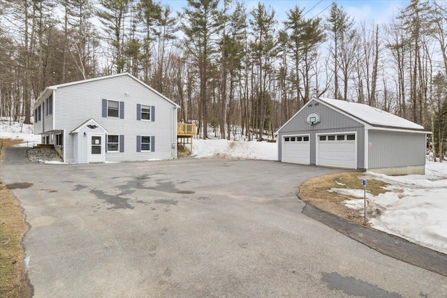 view of snow covered exterior featuring an outdoor structure and a garage