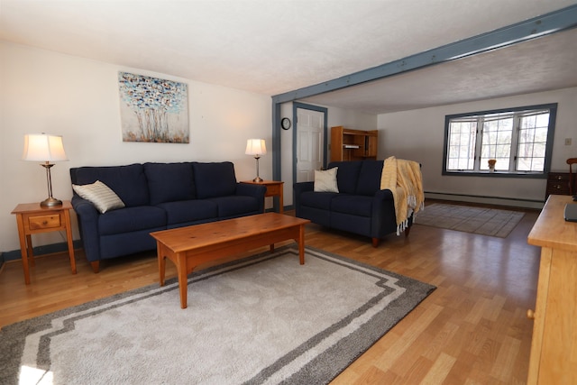 living area featuring a baseboard heating unit, baseboards, and wood finished floors