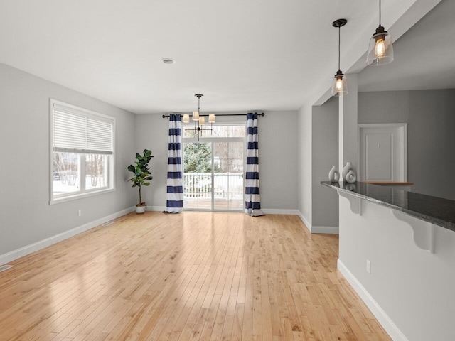 unfurnished dining area with light wood finished floors and baseboards