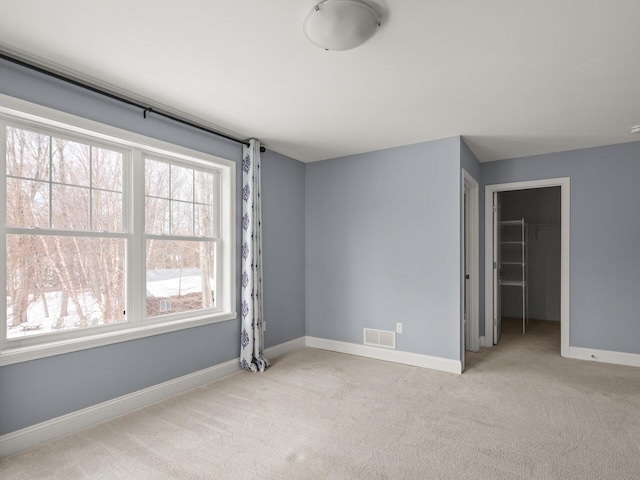 unfurnished room featuring visible vents, carpet flooring, and baseboards