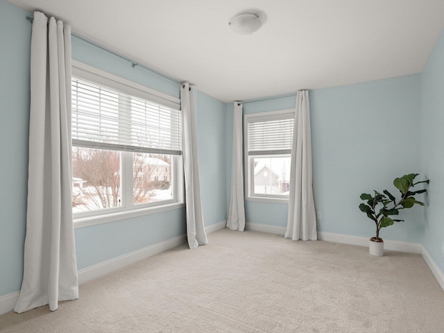 unfurnished room with carpet and baseboards