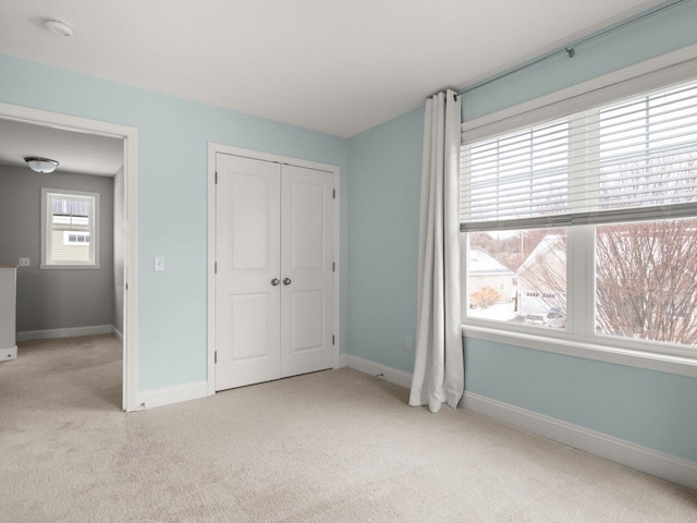 unfurnished bedroom featuring a closet, baseboards, and carpet