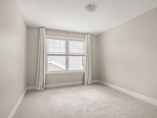 carpeted empty room with baseboards and visible vents