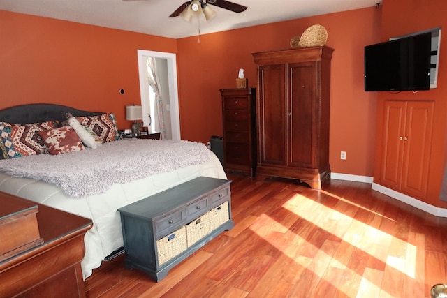 bedroom featuring baseboards, light wood-style floors, and ceiling fan