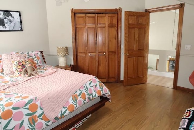 bedroom with a closet, baseboards, and wood finished floors