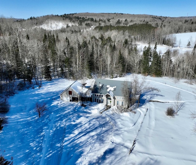 snowy aerial view featuring a view of trees