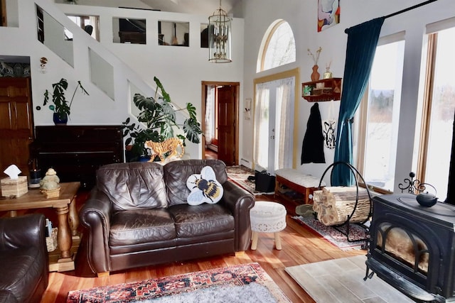 living room featuring a healthy amount of sunlight, a wood stove, and wood finished floors