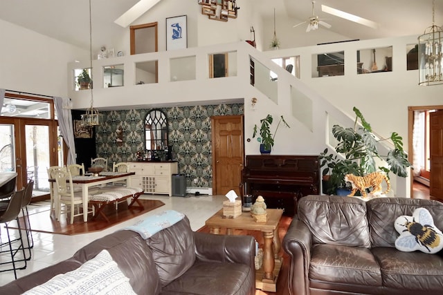 living area with wallpapered walls, high vaulted ceiling, and ceiling fan with notable chandelier