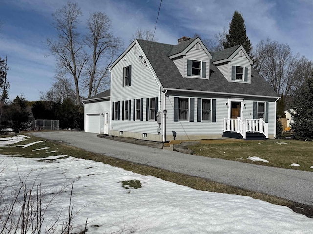 cape cod-style house featuring a chimney, an attached garage, roof with shingles, and driveway