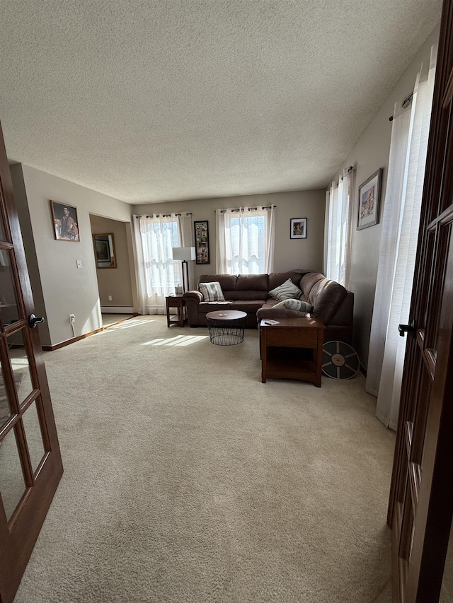 carpeted living area featuring a textured ceiling and baseboards