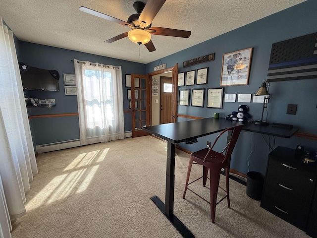 carpeted office with baseboard heating, a textured ceiling, and a ceiling fan