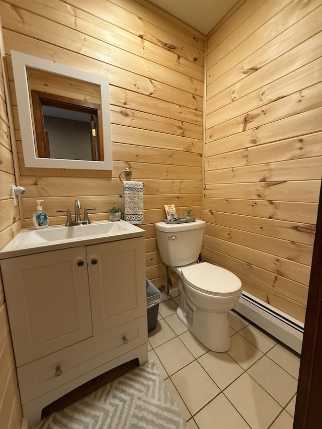 half bath with wooden walls, toilet, baseboard heating, tile patterned floors, and vanity