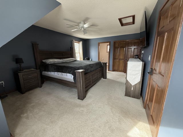 bedroom with light carpet, a textured ceiling, and a ceiling fan