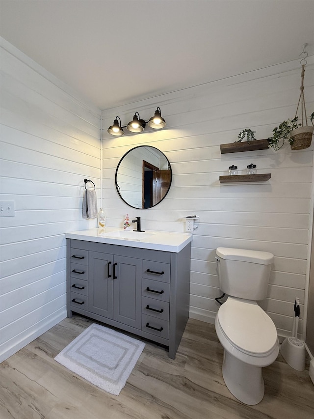 bathroom featuring toilet, wood finished floors, and vanity