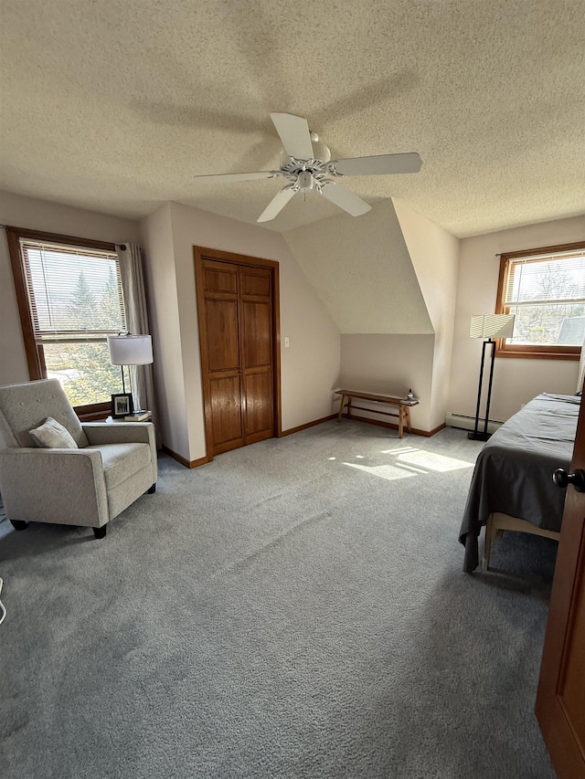 bedroom featuring baseboards, vaulted ceiling, carpet flooring, a ceiling fan, and a baseboard radiator