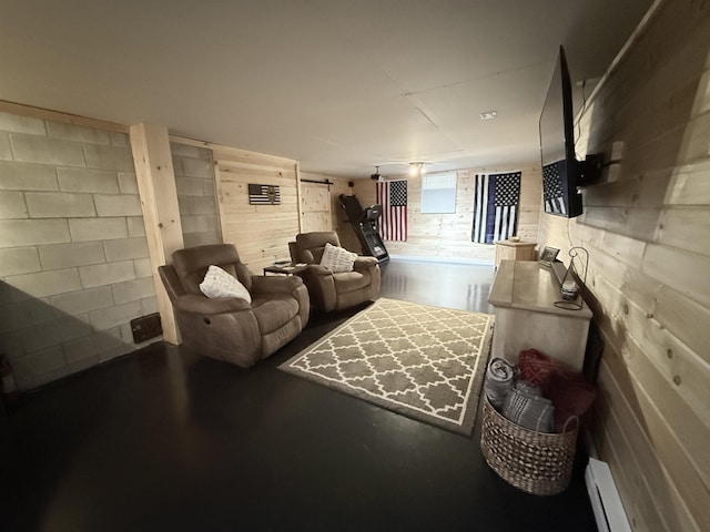 interior space featuring finished concrete floors, wood walls, concrete block wall, and a baseboard radiator