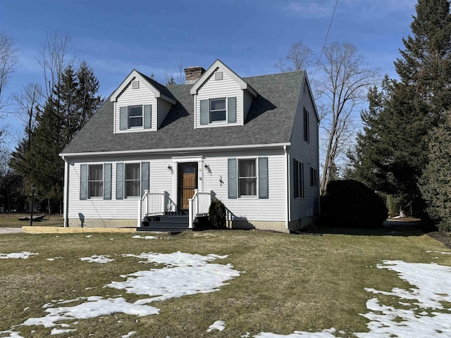 cape cod home featuring a yard, roof with shingles, and a chimney