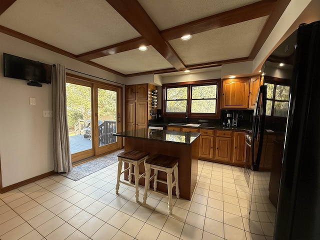 kitchen with light tile patterned flooring, brown cabinets, a kitchen breakfast bar, and a kitchen island