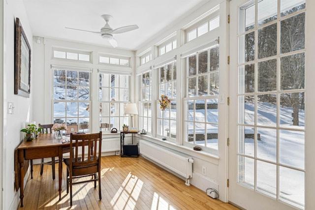 sunroom / solarium featuring radiator heating unit and ceiling fan