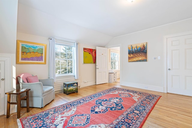 sitting room with vaulted ceiling, baseboards, and wood finished floors