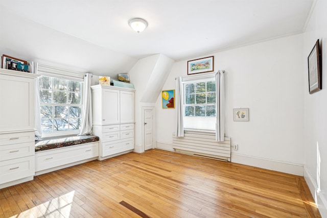 interior space with light wood finished floors, baseboards, and lofted ceiling