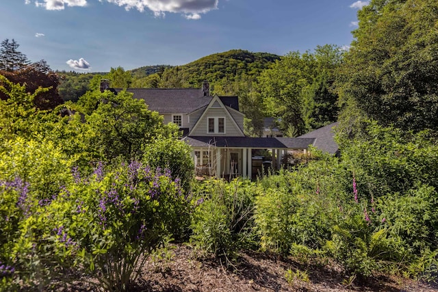 rear view of house featuring a forest view