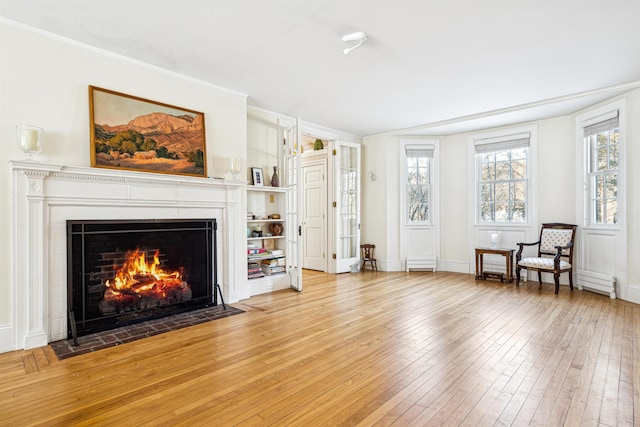 living area with a fireplace with flush hearth and light wood-style floors