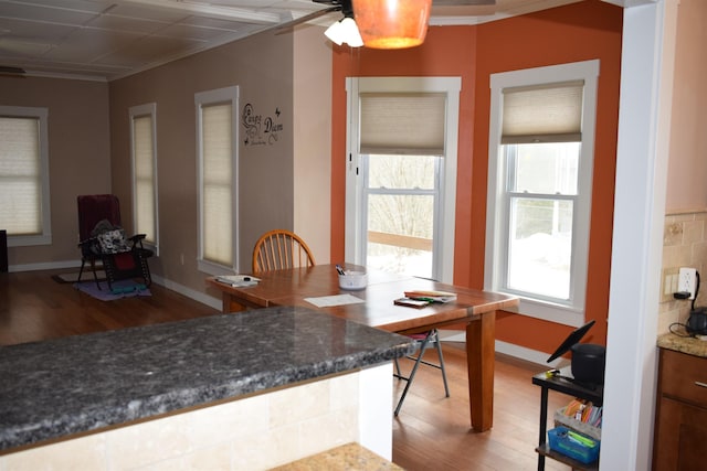 dining area with baseboards, light wood-style flooring, and crown molding