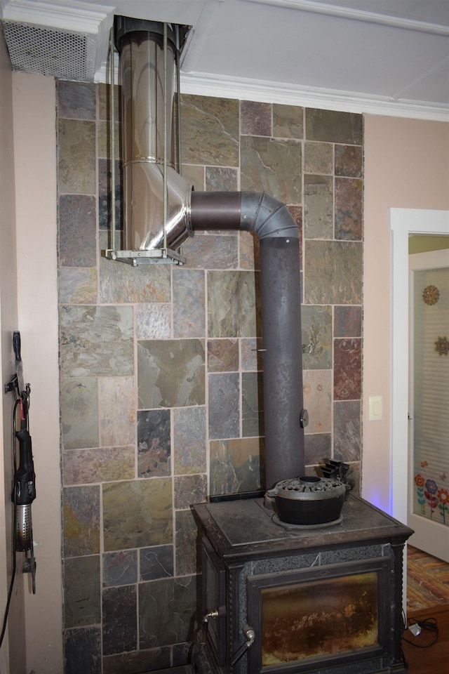 details featuring a wood stove and ornamental molding