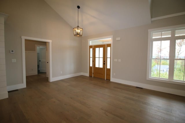 foyer entrance with wood finished floors, baseboards, and high vaulted ceiling