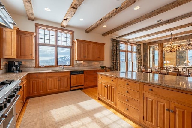 kitchen featuring a sink, range with two ovens, decorative backsplash, light stone countertops, and dishwasher