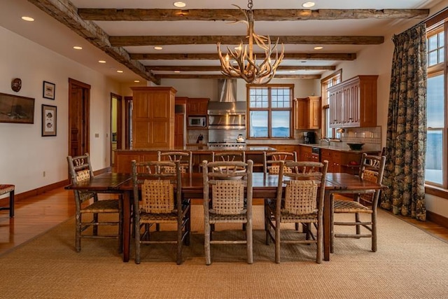 dining area with beamed ceiling, light wood-style flooring, recessed lighting, an inviting chandelier, and baseboards