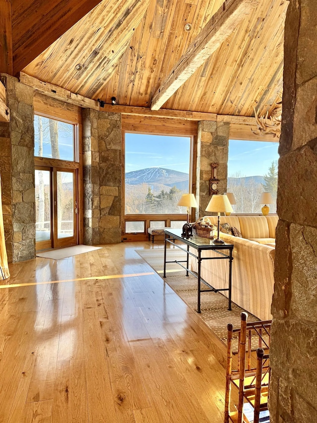 doorway to outside with a mountain view, wooden ceiling, lofted ceiling with beams, and hardwood / wood-style flooring