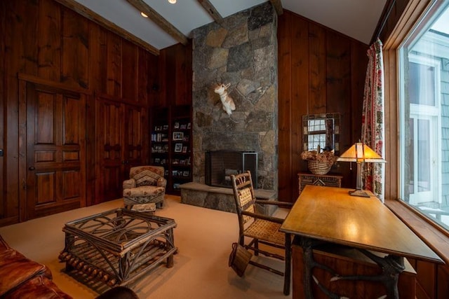 interior space featuring beam ceiling, high vaulted ceiling, wood walls, and a fireplace